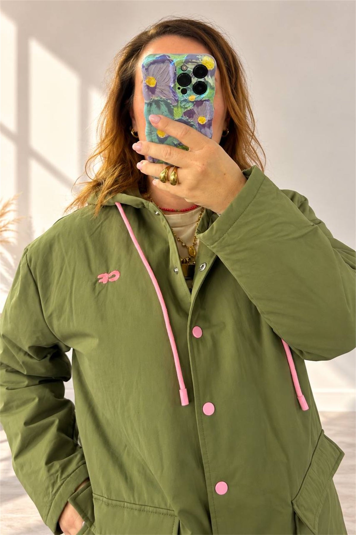 Parka verde militare, dettaglio del cappuccio e della coulisse rosa a contrasto