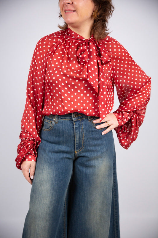 Tensione in blusa rossa a pois con fiocco