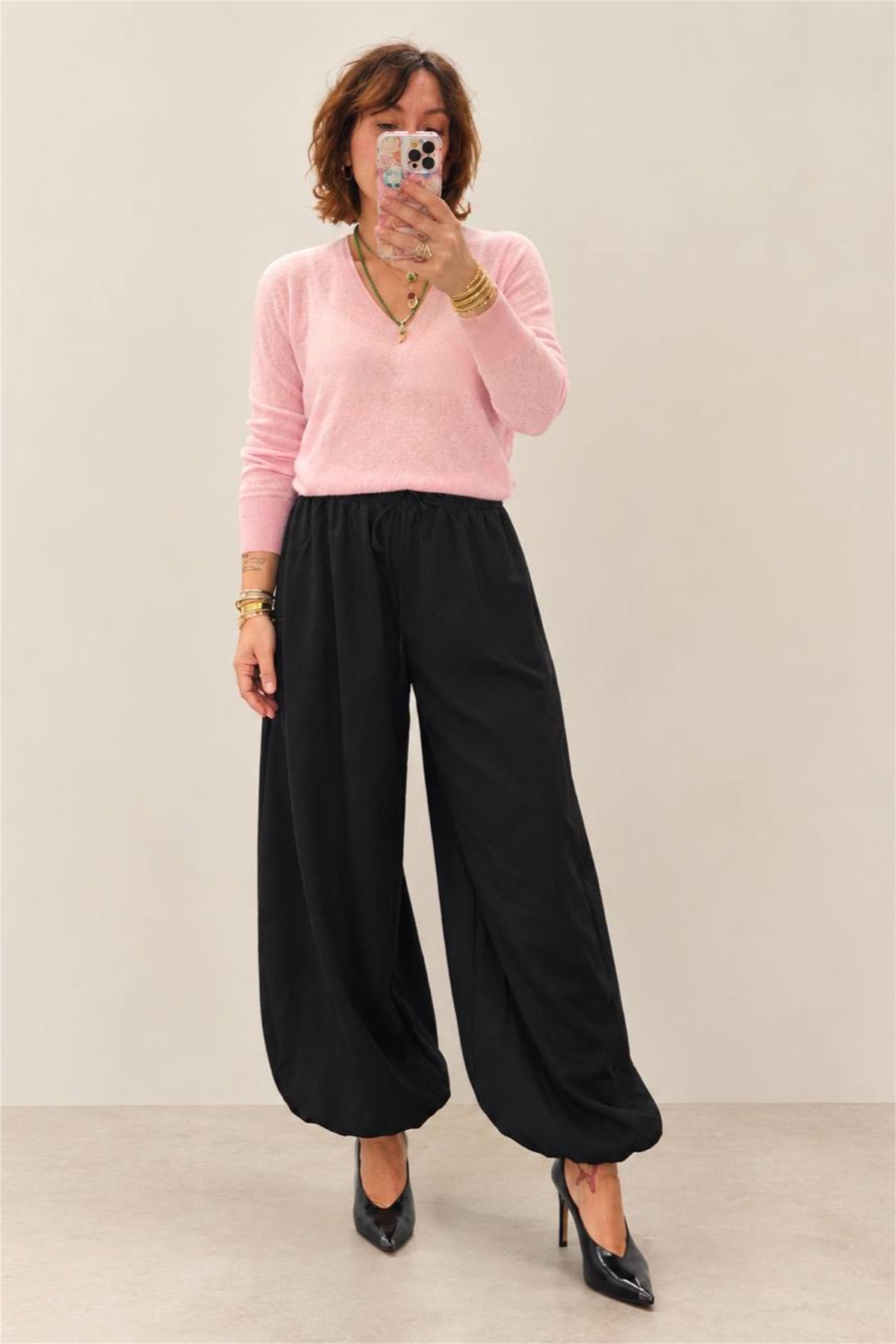 Pantalone jogger nero indossato con maglia rosa, vista frontale intera