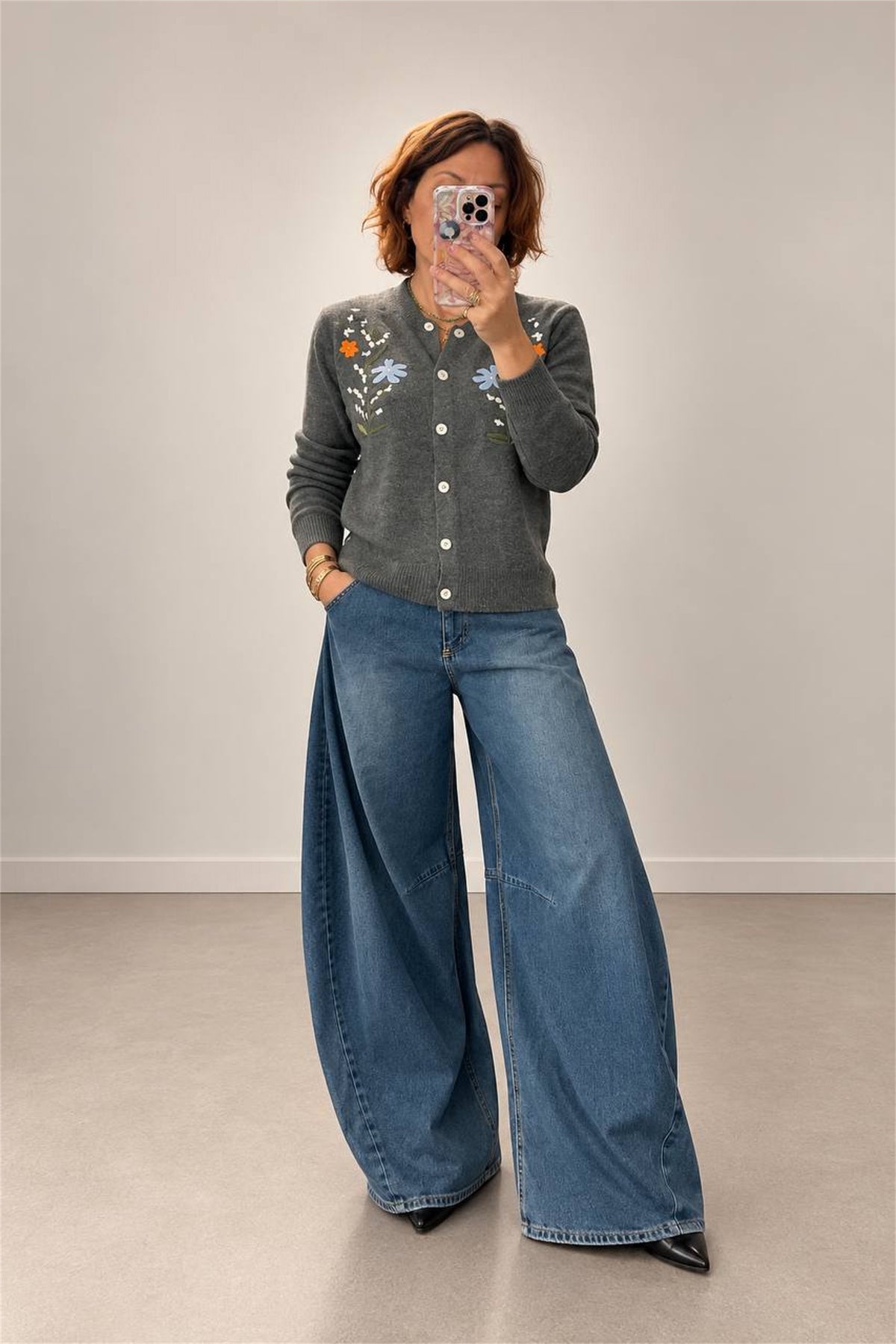 Cardigan grigio con ricamo floreale indossato a figura intera con jeans ampi