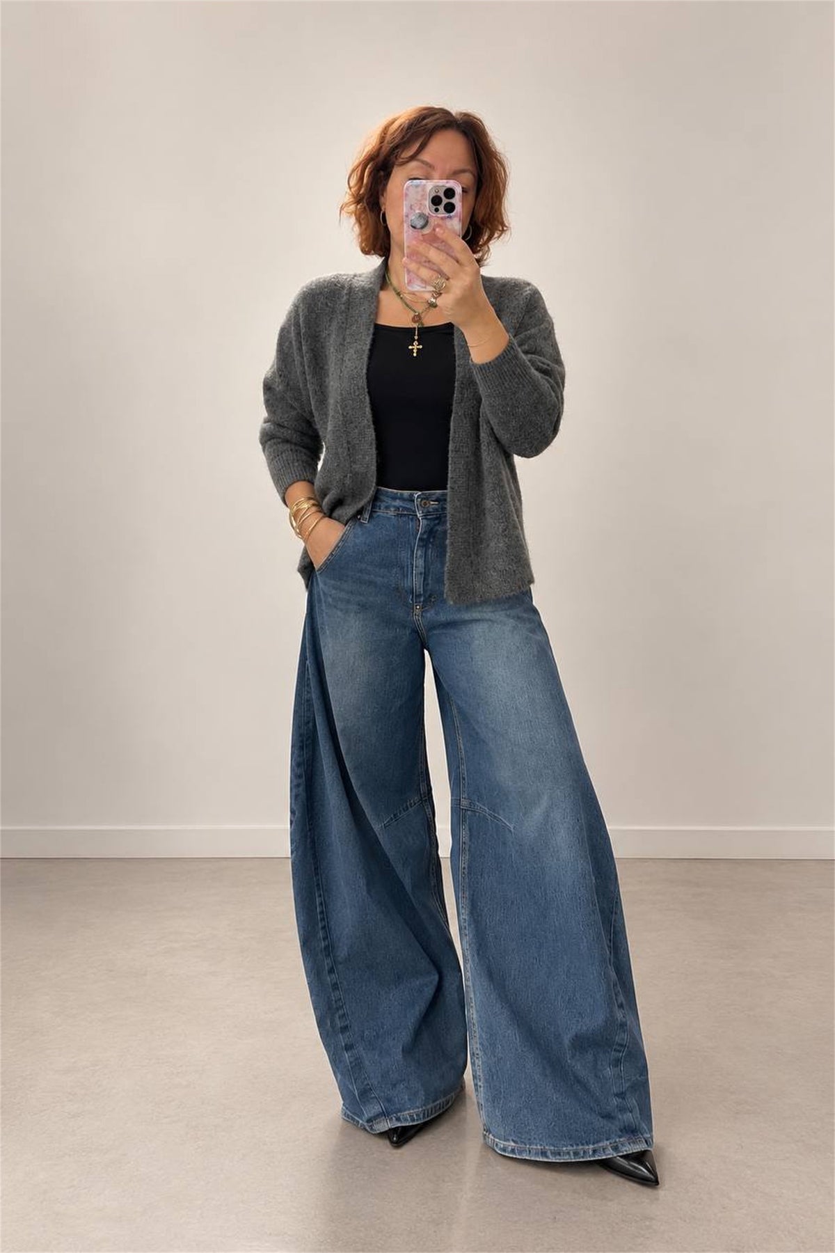 Cardigan grigio melange indossato con jeans ampi, vista frontale a figura intera