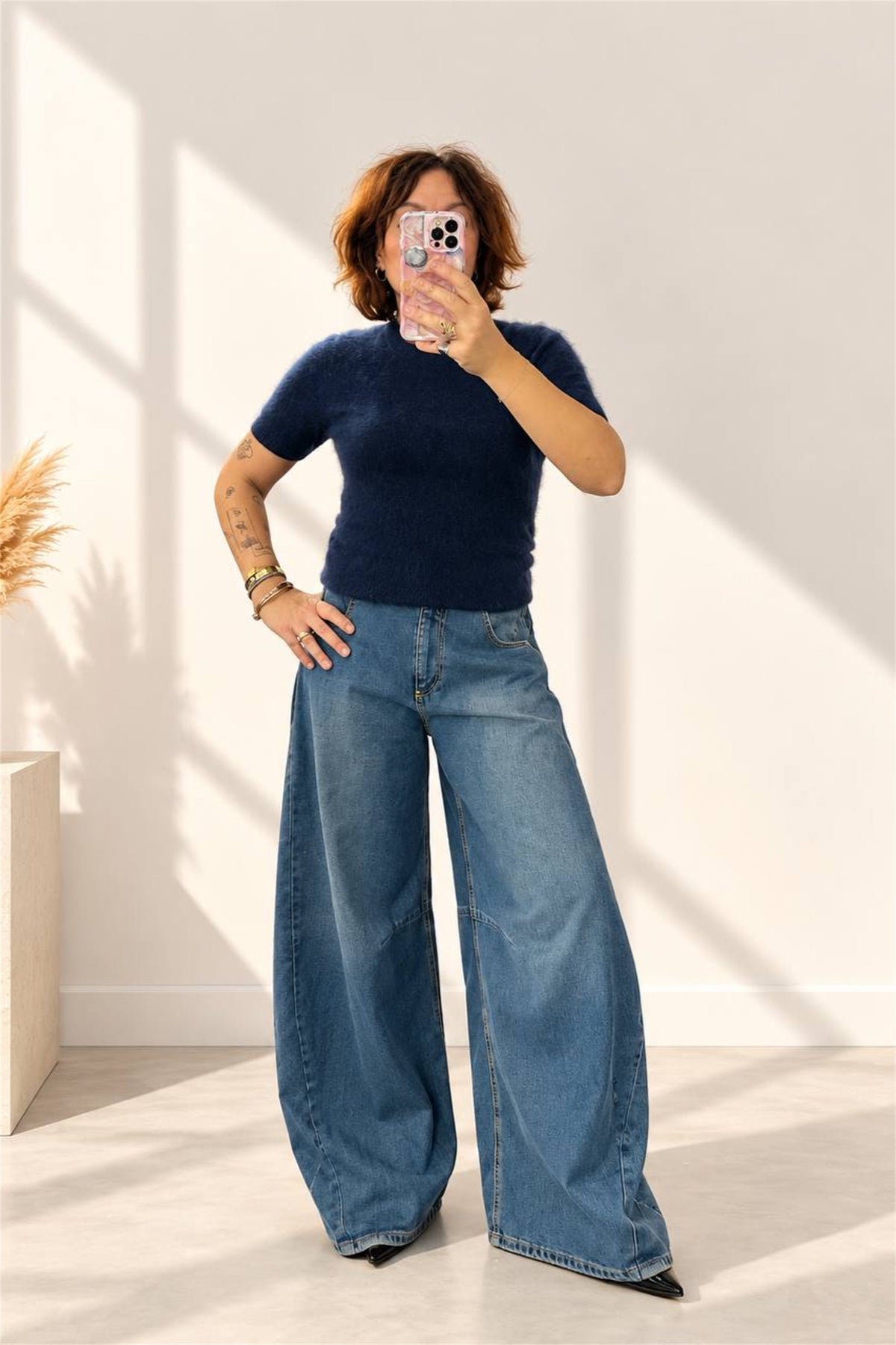 Donna indossa maglia blu in lana e cashmere con jeans ampi, vista frontale
