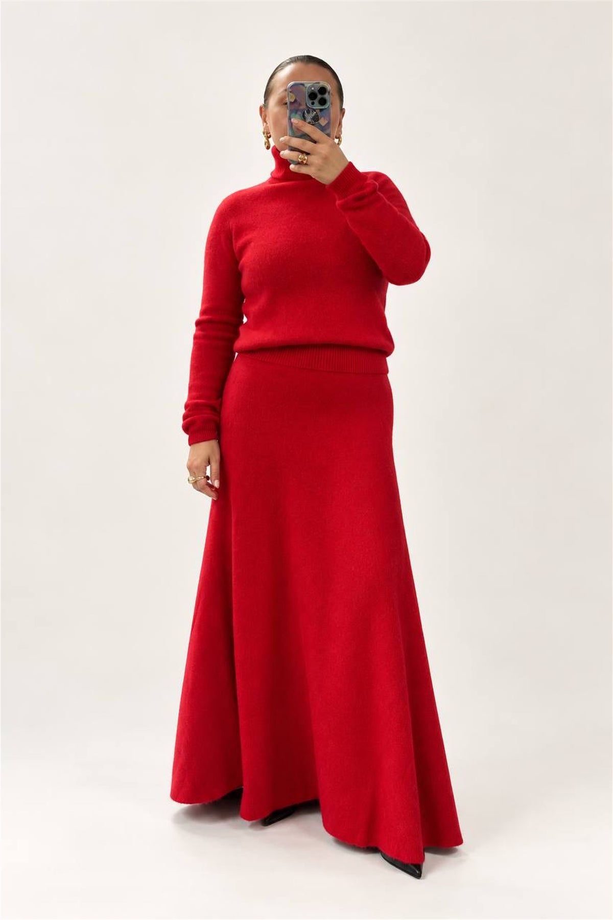 Dolcevita rosso in lana indossato con gonna coordinata, vista intera