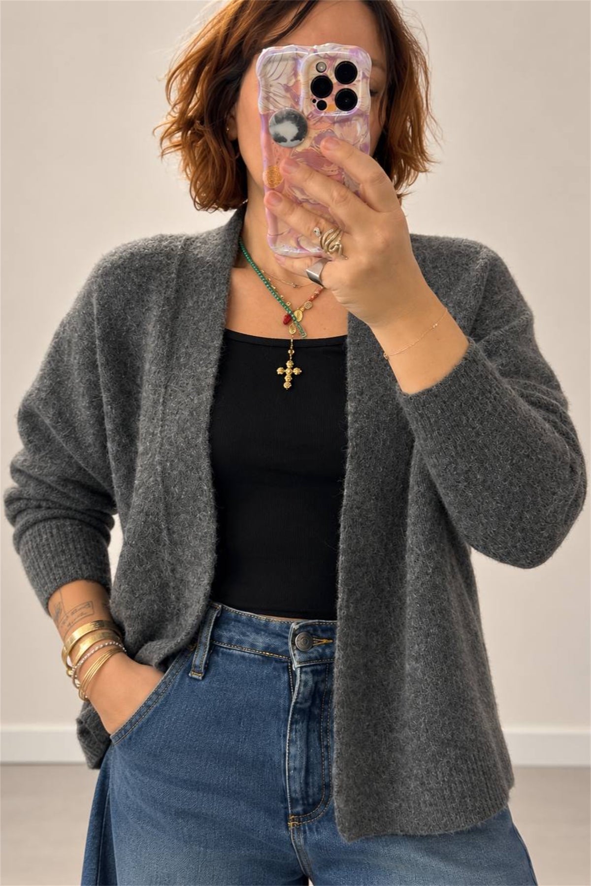 Cardigan grigio melange indossato, dettaglio scollo e maniche