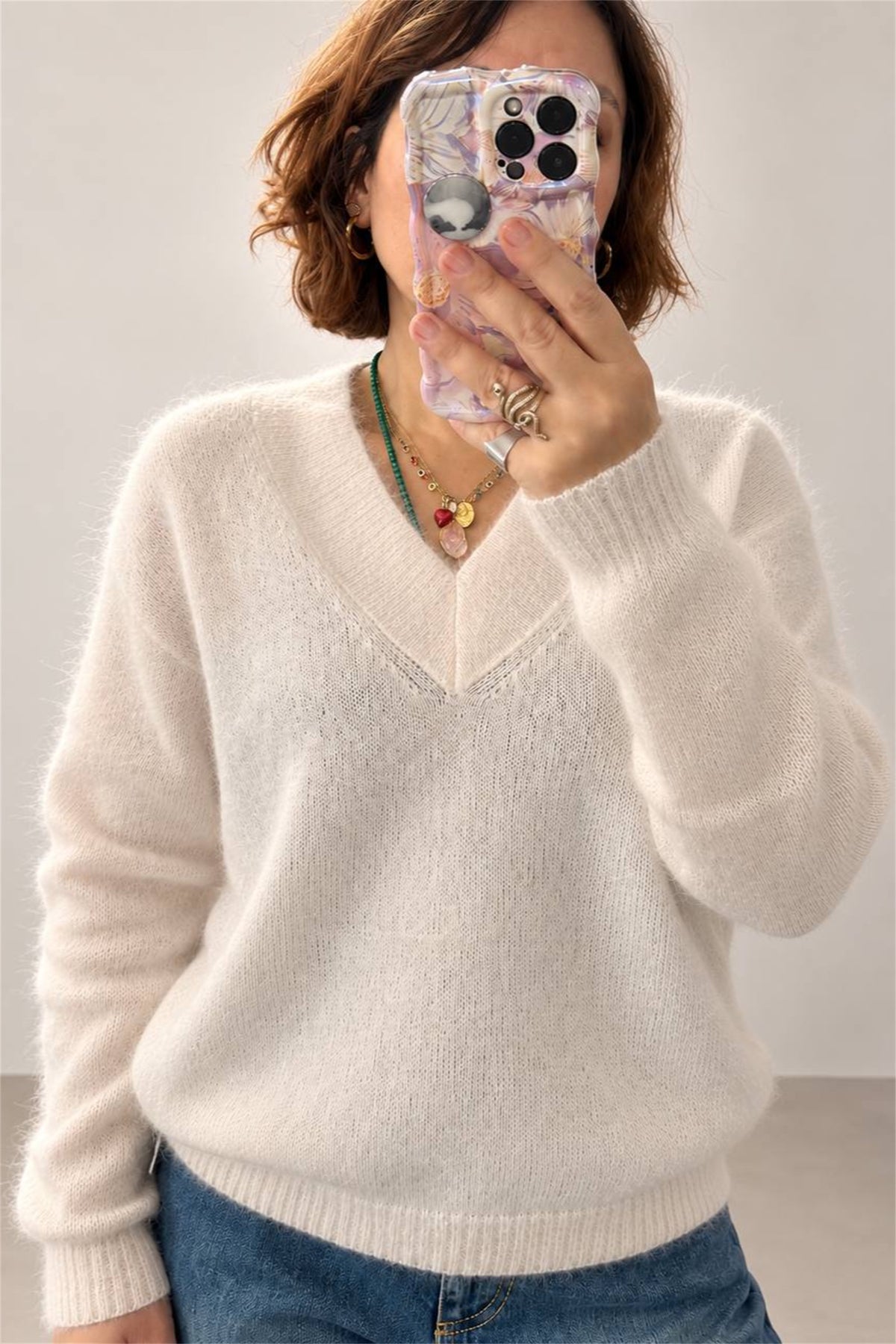 Maglione rosa baby con scollo a V, dettaglio ravvicinato del tessuto e della lavorazione